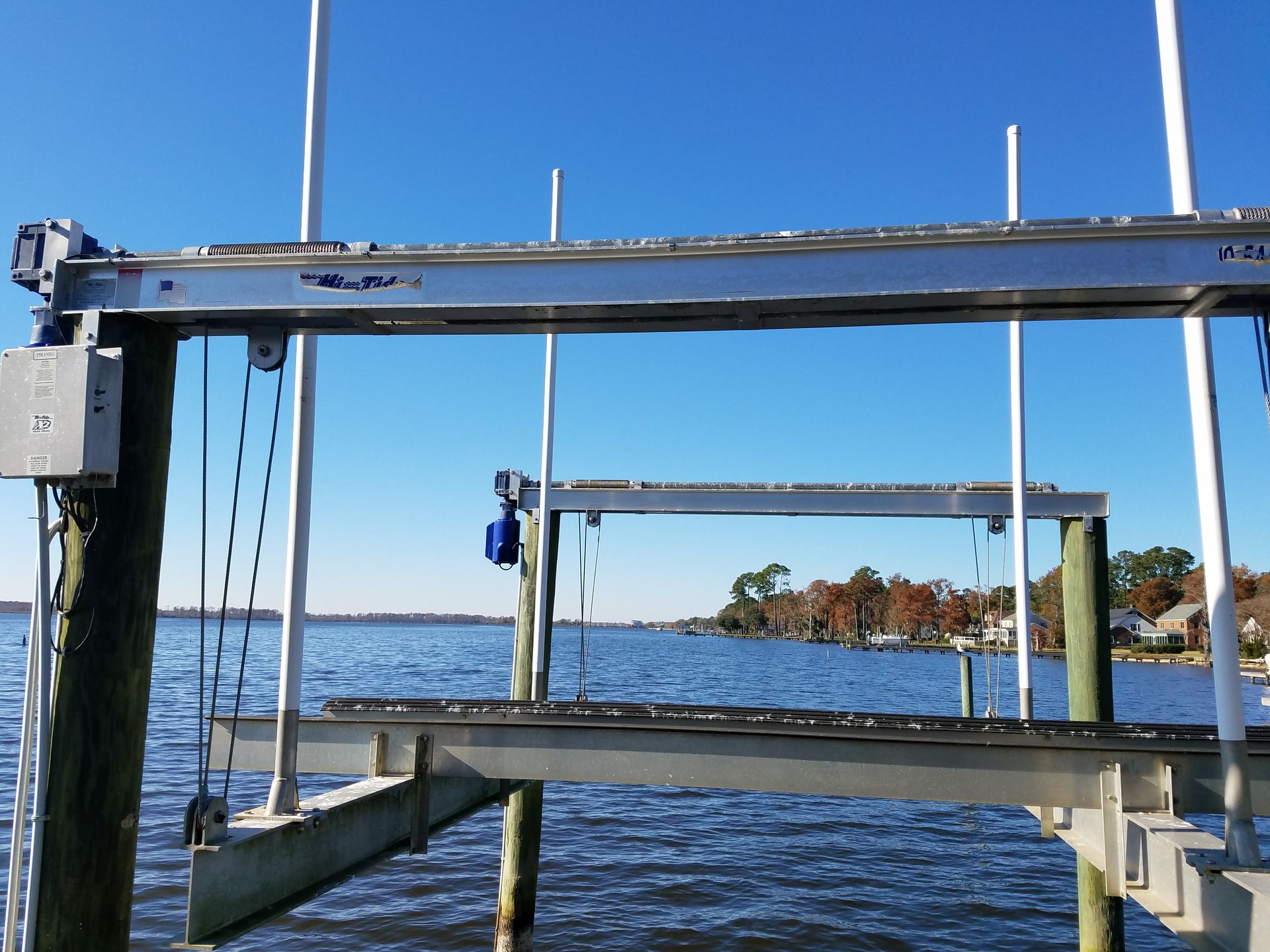 Boat lift on a lake with blue water and shoreline in the background