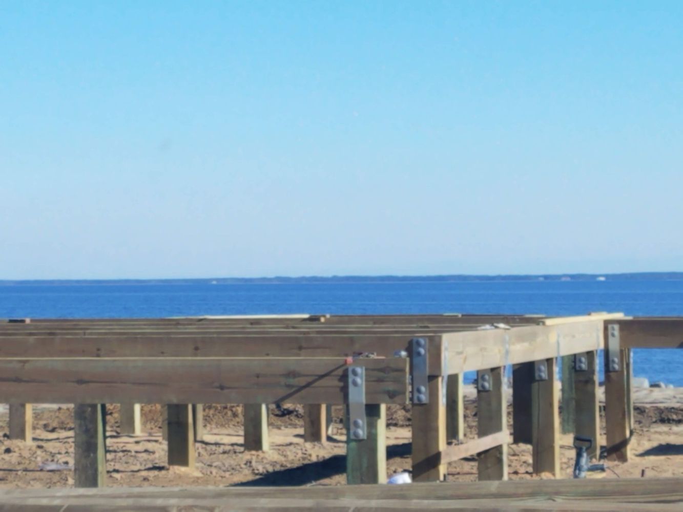 Beach boardwalk overlooking blue ocean under a clear sky
