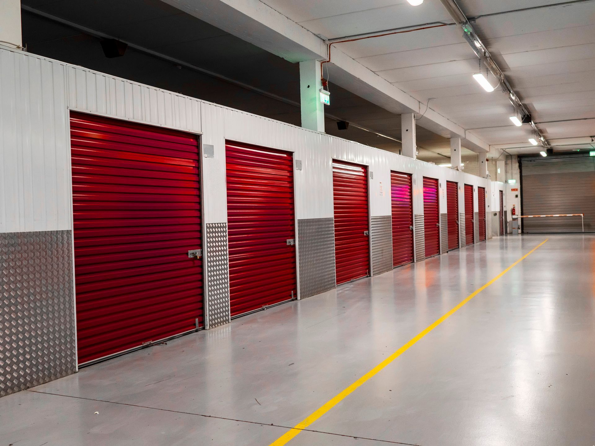 A long row of red-colored doors of a self-storage facility. A long row of red-colored doors of a self-storage facility.