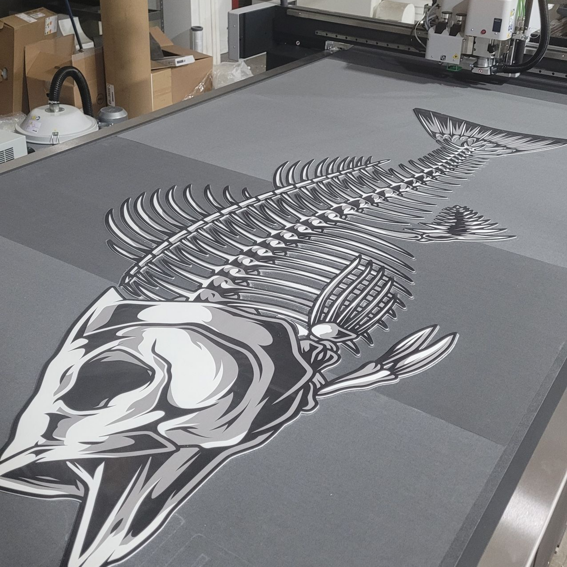 Large fish skeleton graphic printed on gray fabric on a flatbed printer