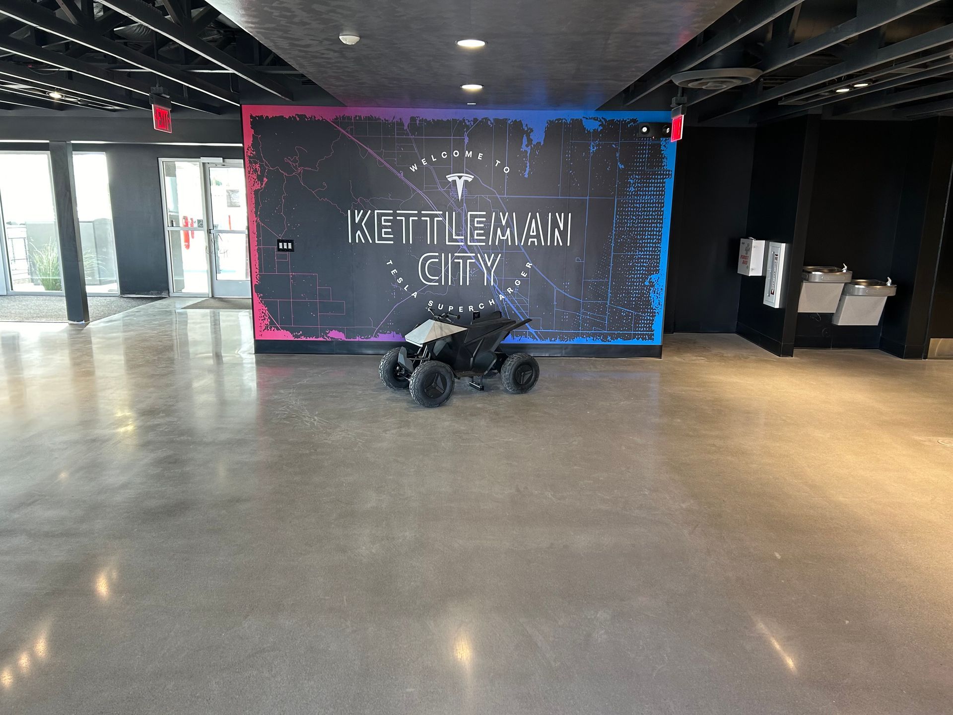 Small all-terrain vehicle in a lobby with a large “Netherlands City” wallpaper and pink-blue neon backdrop