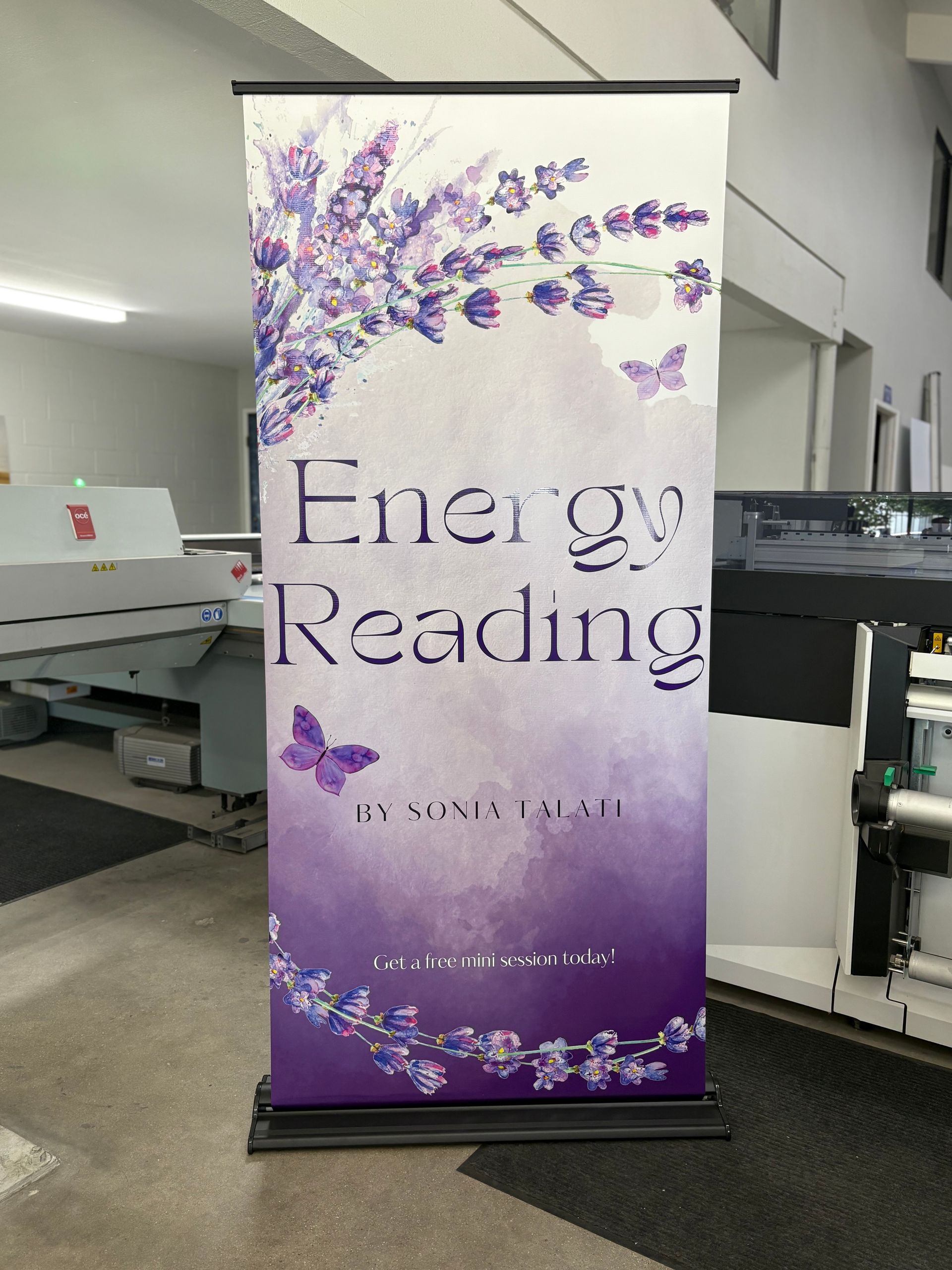 Purple banner for an energy reading service with floral accents in a lobby