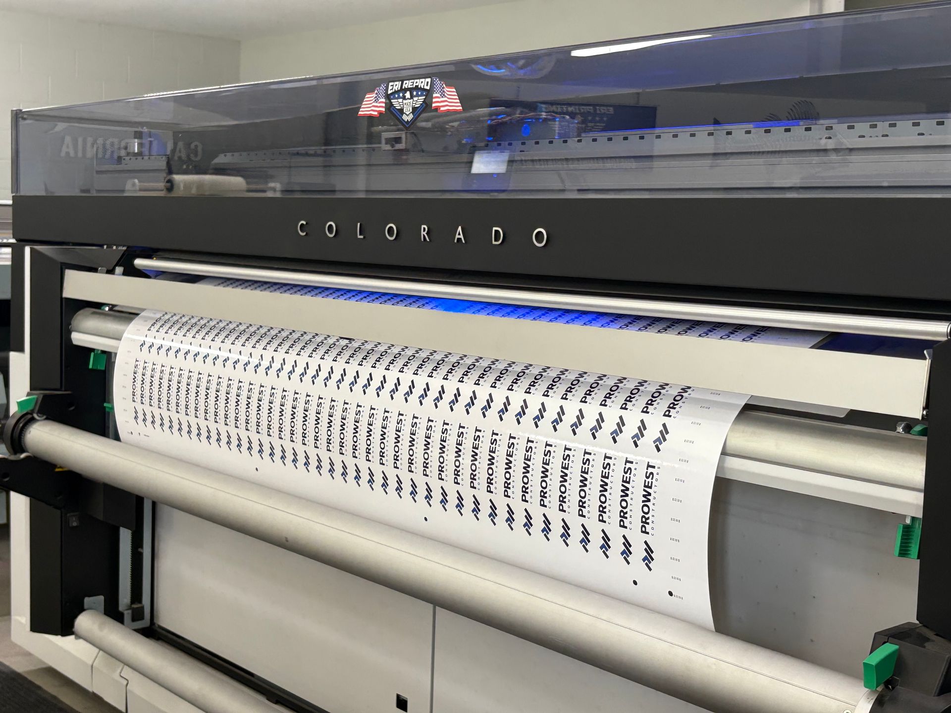 Large-format printer printing a long sheet of patterned text on white paper