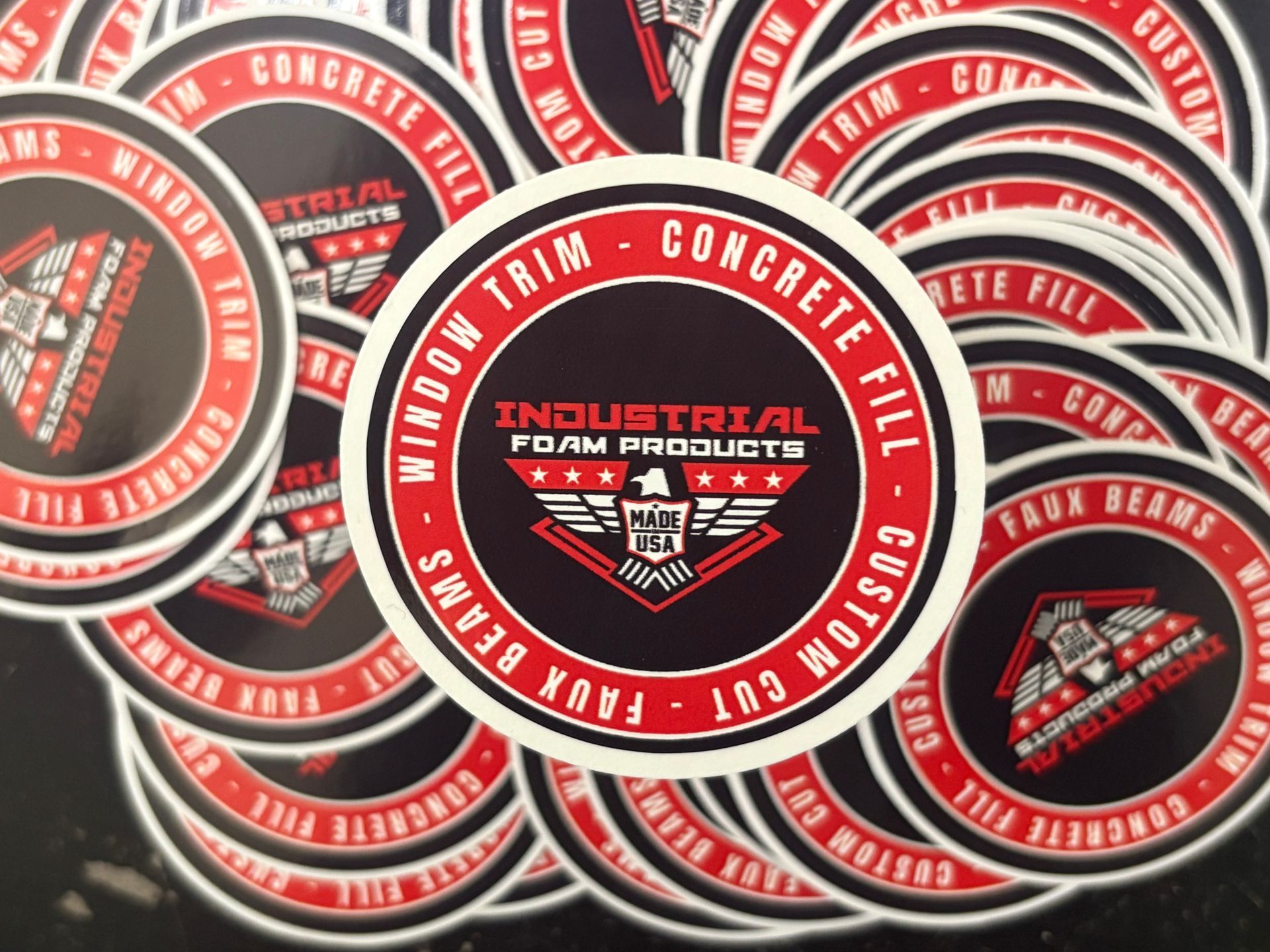 Stacked red-and-black Industrial Foam Products cans with circular labels and cream sealant branding