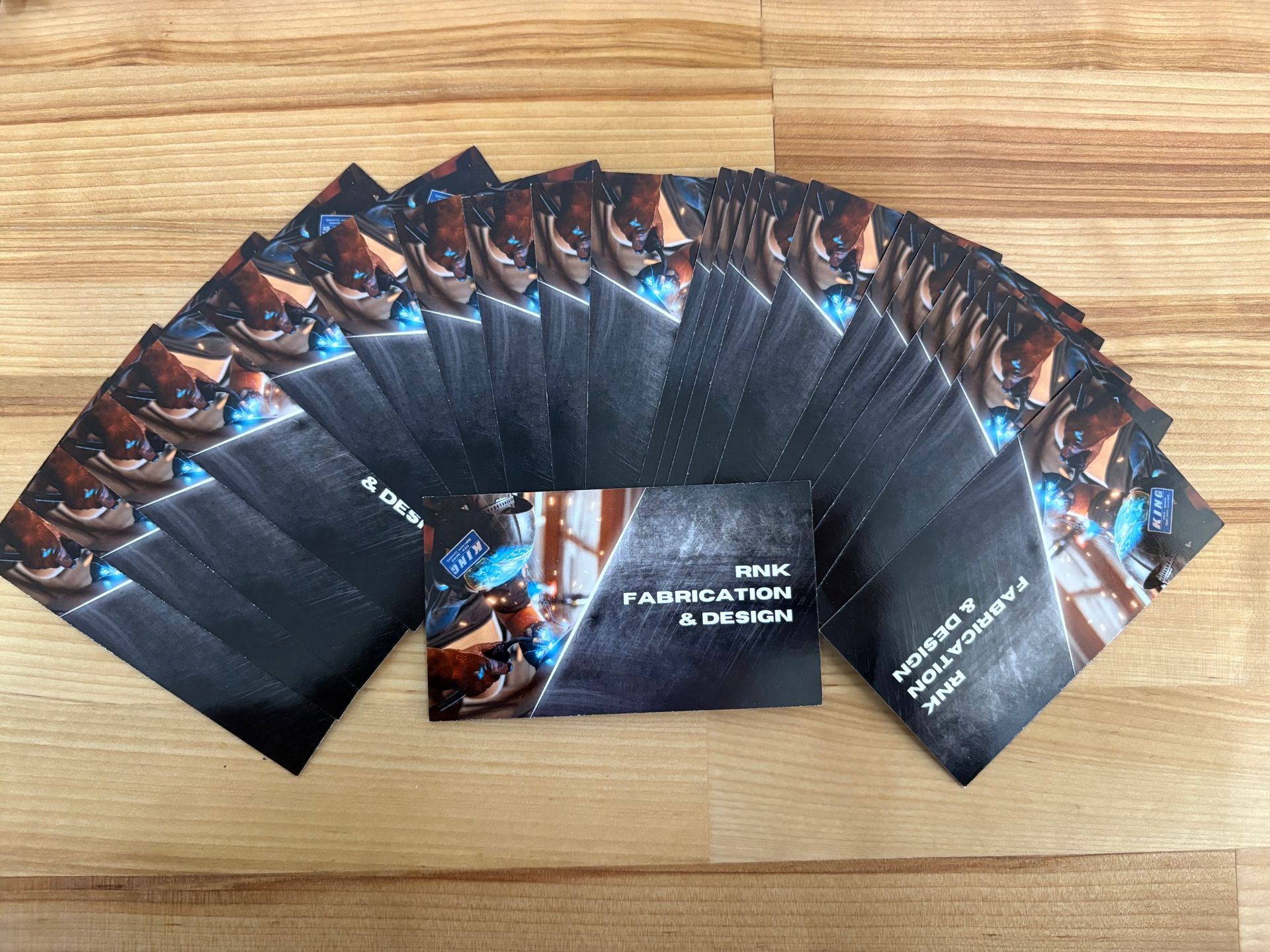 Fan-shaped spread of glossy blue-and-black business cards with a matching booklet in the center
