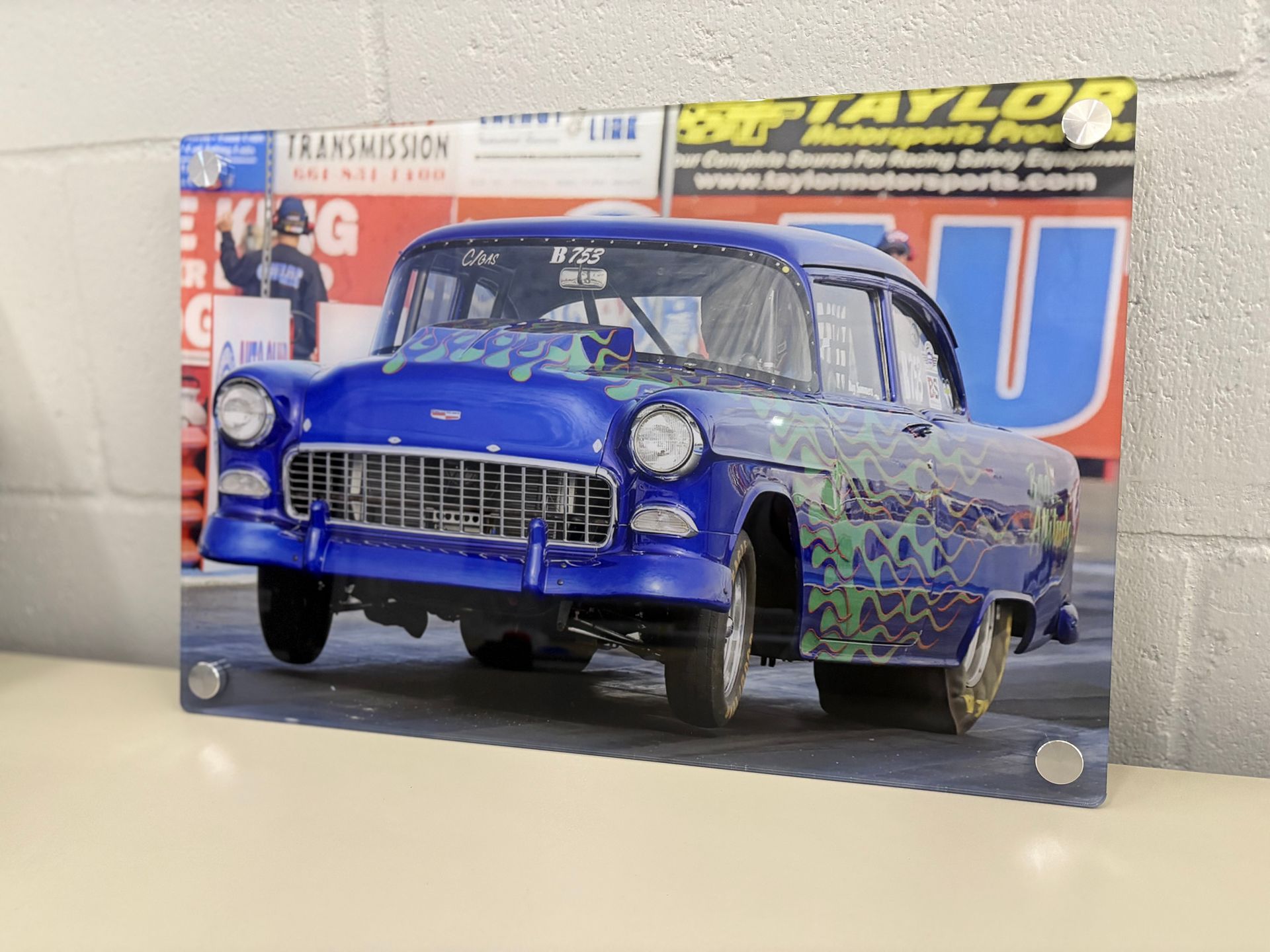 Blue vintage car model on a display board with bold yellow and red lettering in the background
