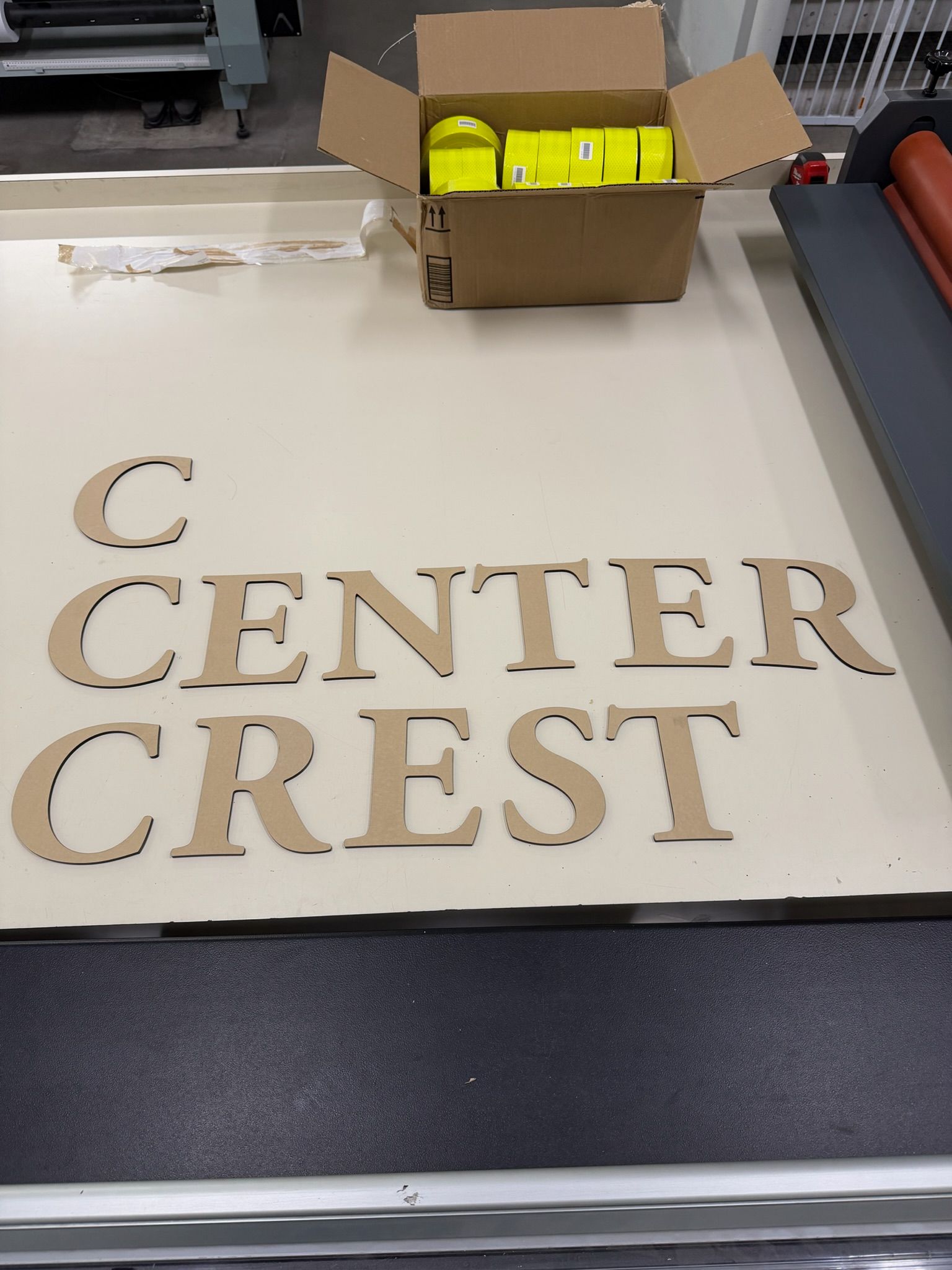 Cardboard box with yellow items on a table above a “CENTER CREST” sign.