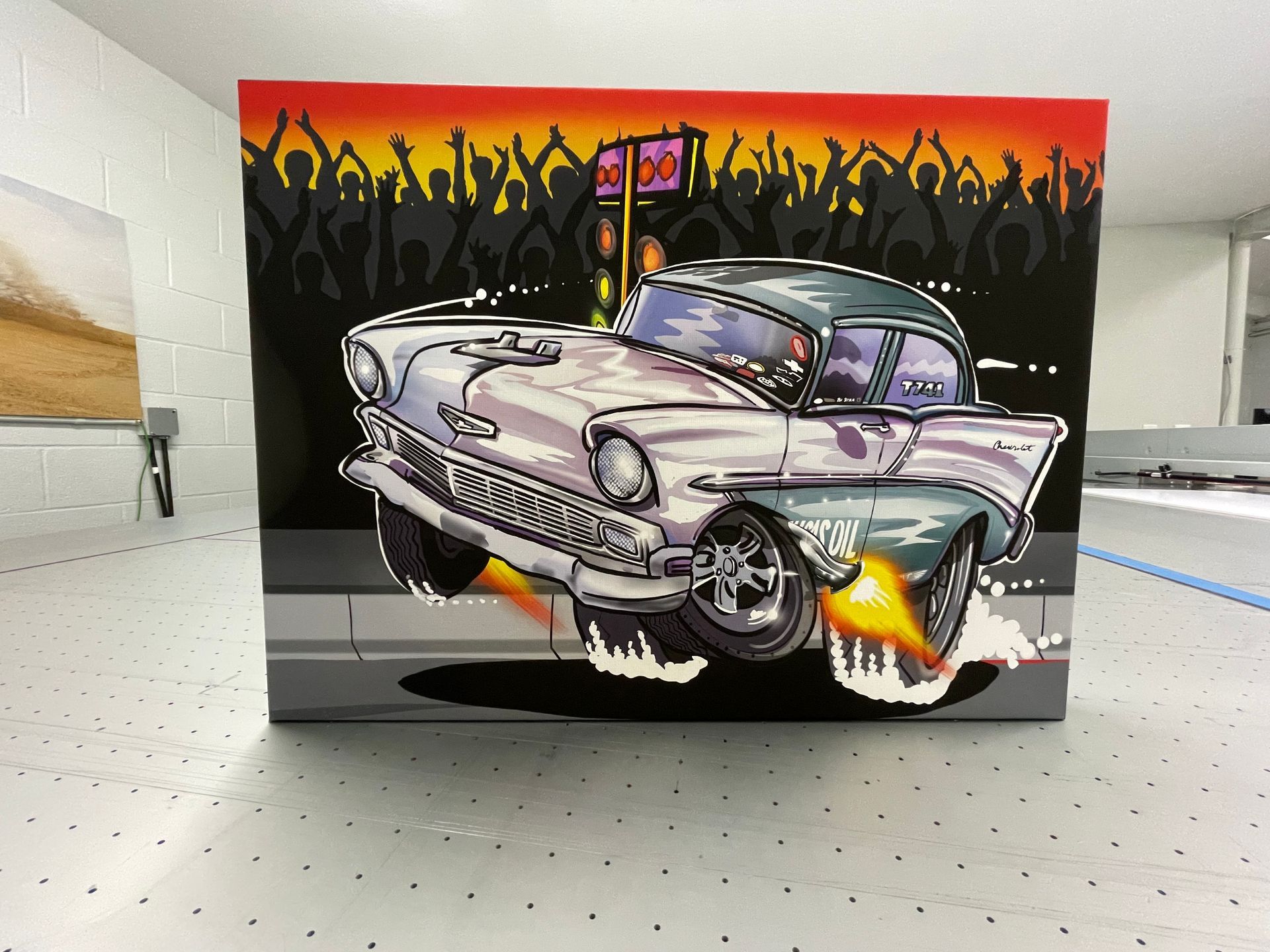 Graffiti mural of a purple classic car with flaming tires against a black-and-red background