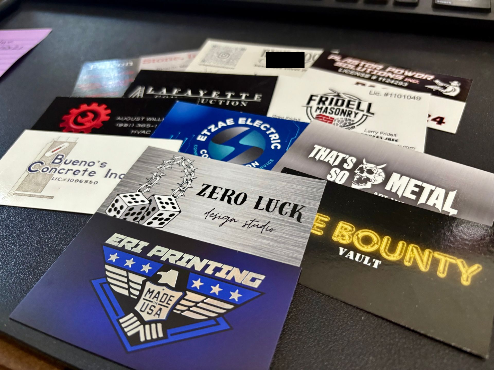Assorted printed patches and labels on a black surface, including “Zero Luck,” “That’s Metal,” and “Body Count”