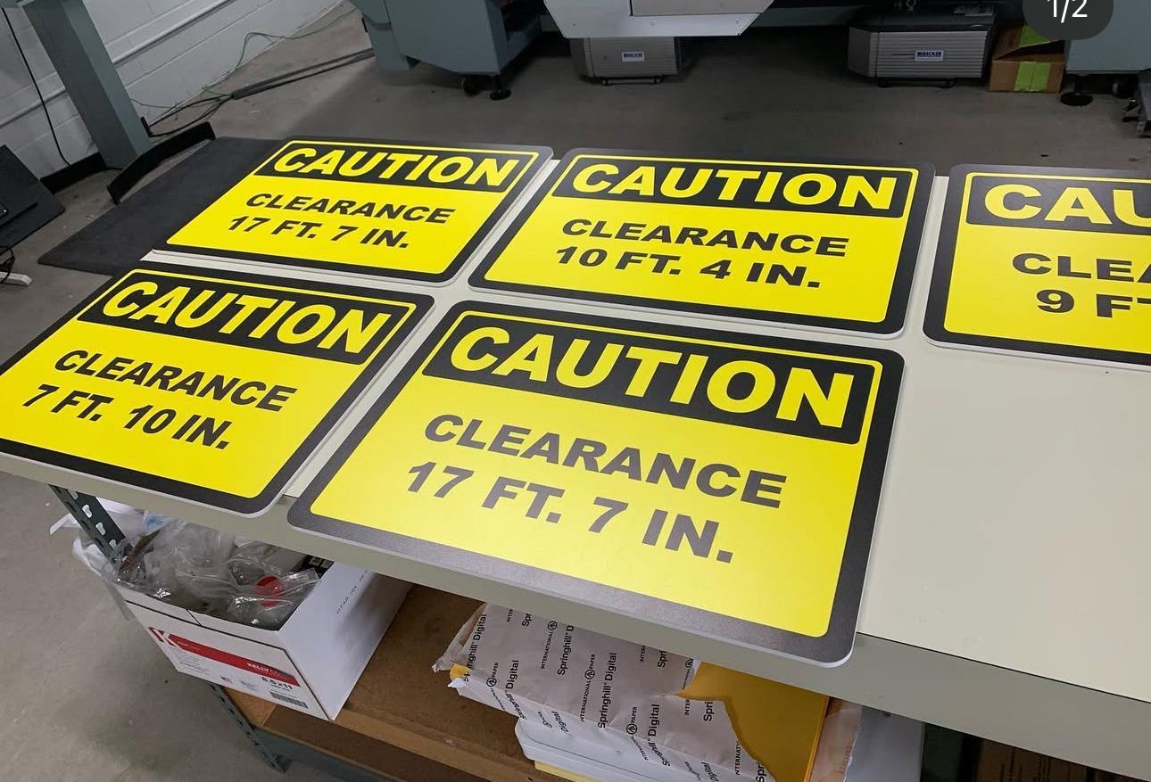 Yellow caution signs on a table, warning of 17 ft. 7 in. clearance.