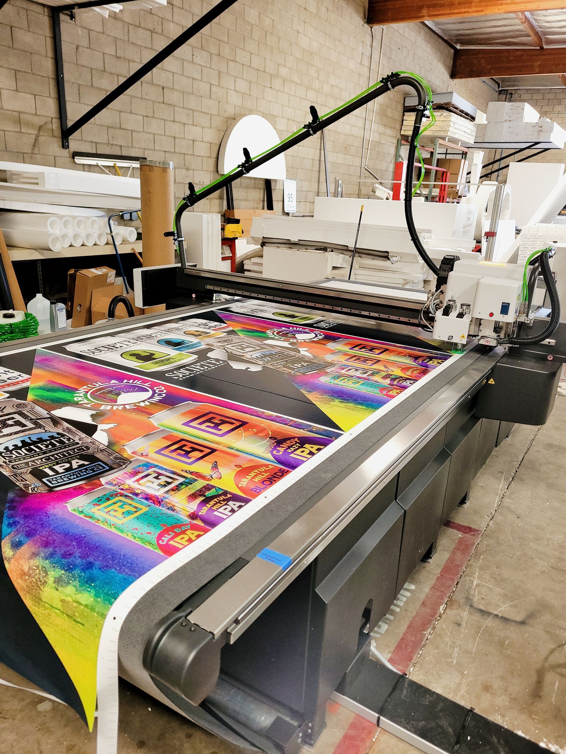 Large-format printer producing a vibrant multicolor banner in a workshop