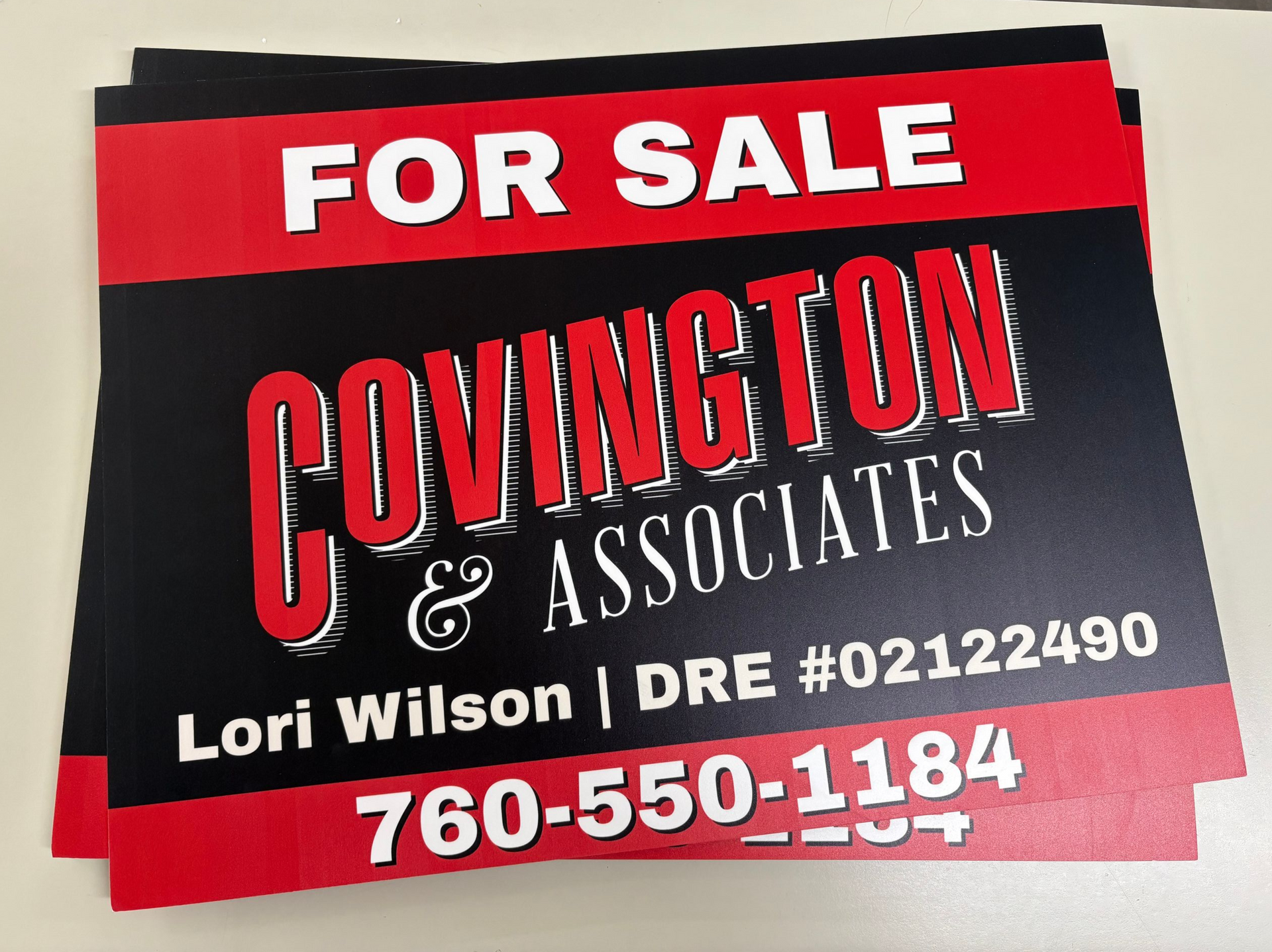 Red and black Covington Associates real estate for sale sign with Lori Wilson and phone number 760-550-1184