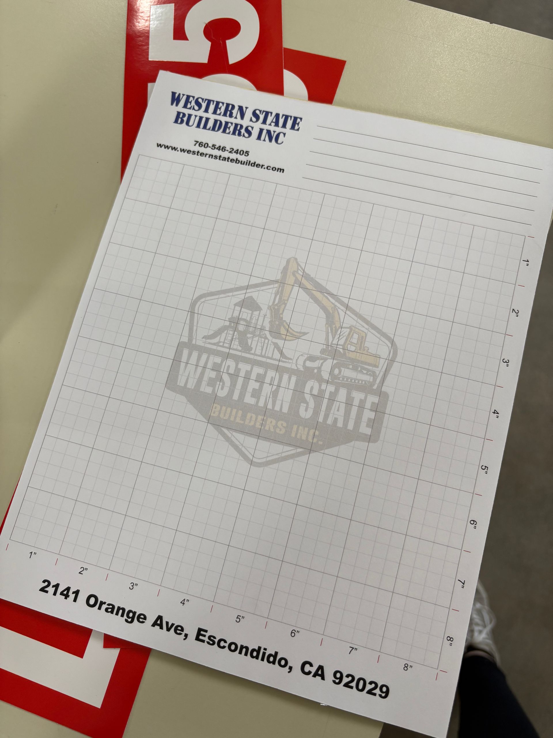 Western State Building Inc. letterhead on a desk, with red and black text and a faint logo