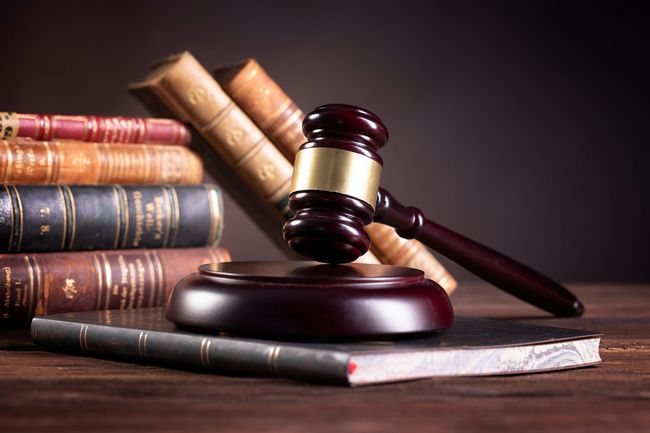 Law books and a judge’s gavel on a wooden desk