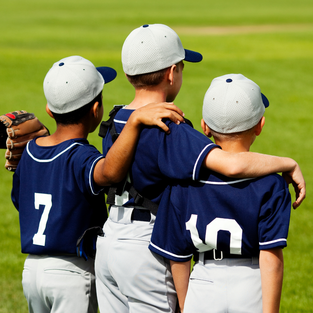 Baseball player sliding into base as another player attempts to catch the ball.