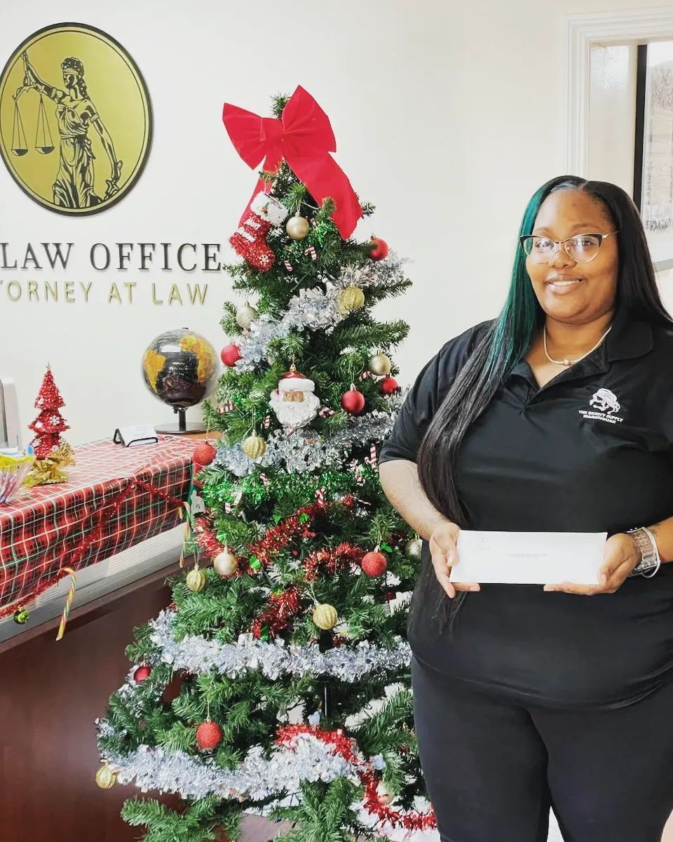 A Blaise Law Office client showing a check that represents their personal injury law suit results.