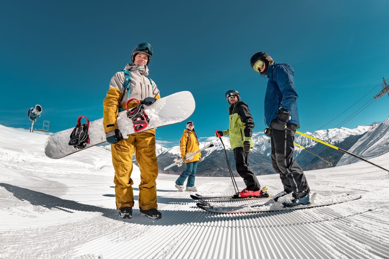 Un grupo de personas está de pie en la cima de una montaña cubierta de nieve.