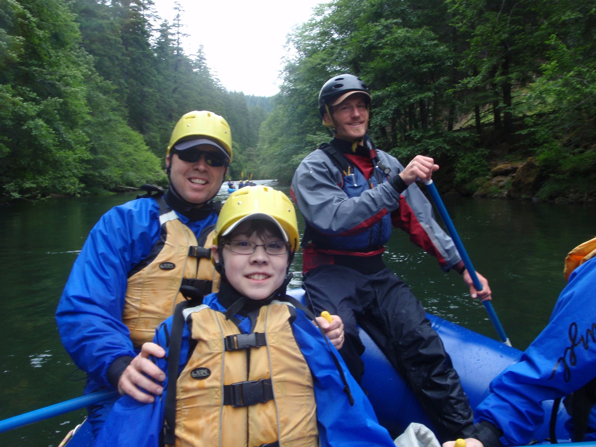 A group of people are sitting in a raft on a river
