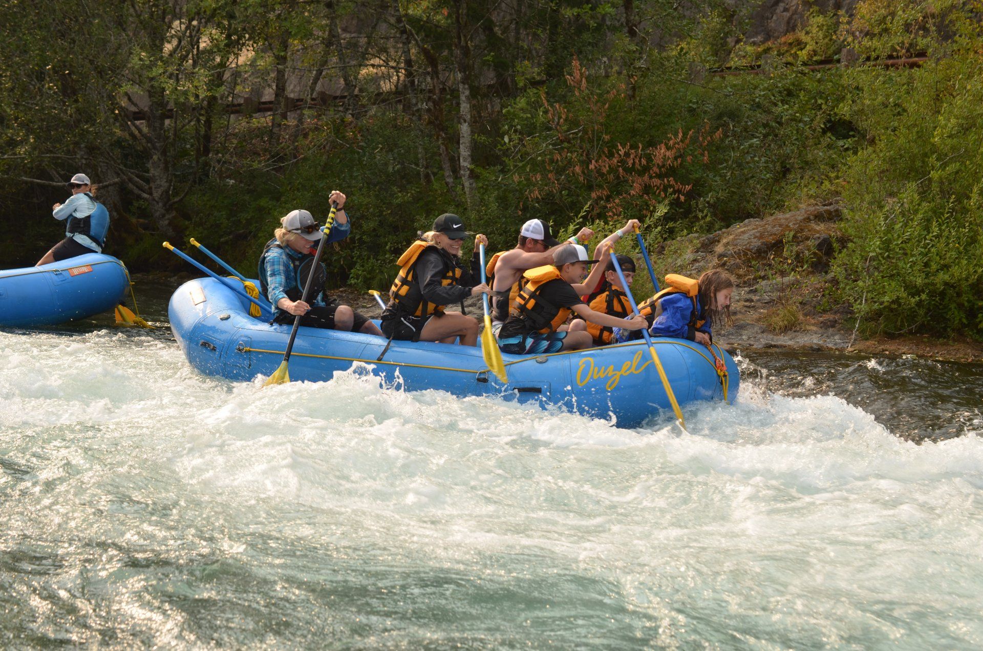 A group paddling through whitewater on  McKenzie River rafting adventure. 