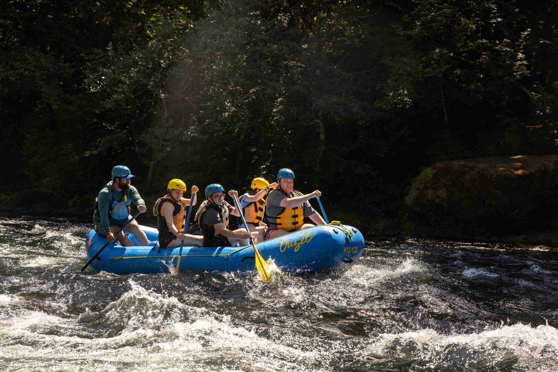 A group of Ouzel guests are paddling down a river.