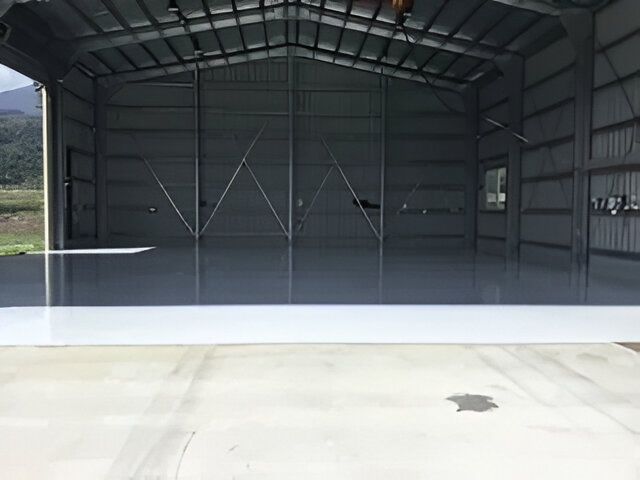 A Large Warehouse With a Concrete Floor and a Sliding Door — RPS–Remote Painting Services in White Rock, QLD