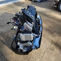 Severely damaged motorcycle lying on a road, with broken front fairing and exposed engine parts.