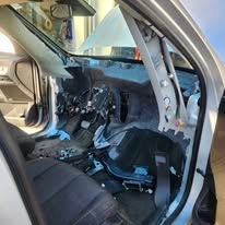 Damaged car interior with deployed airbags and a crushed dashboard after a crash