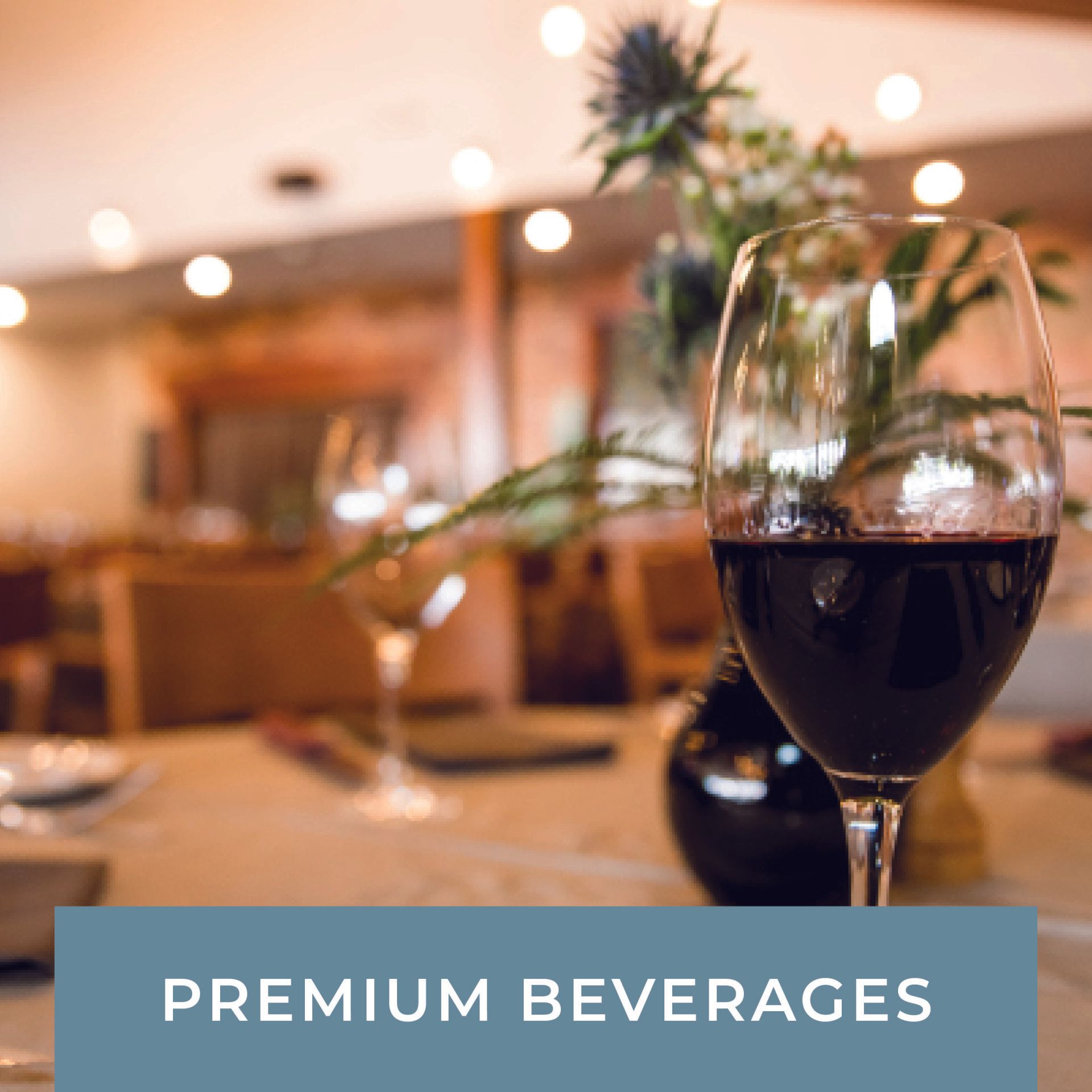 A glass of wine sits on a table next to a sign that says premium beverages