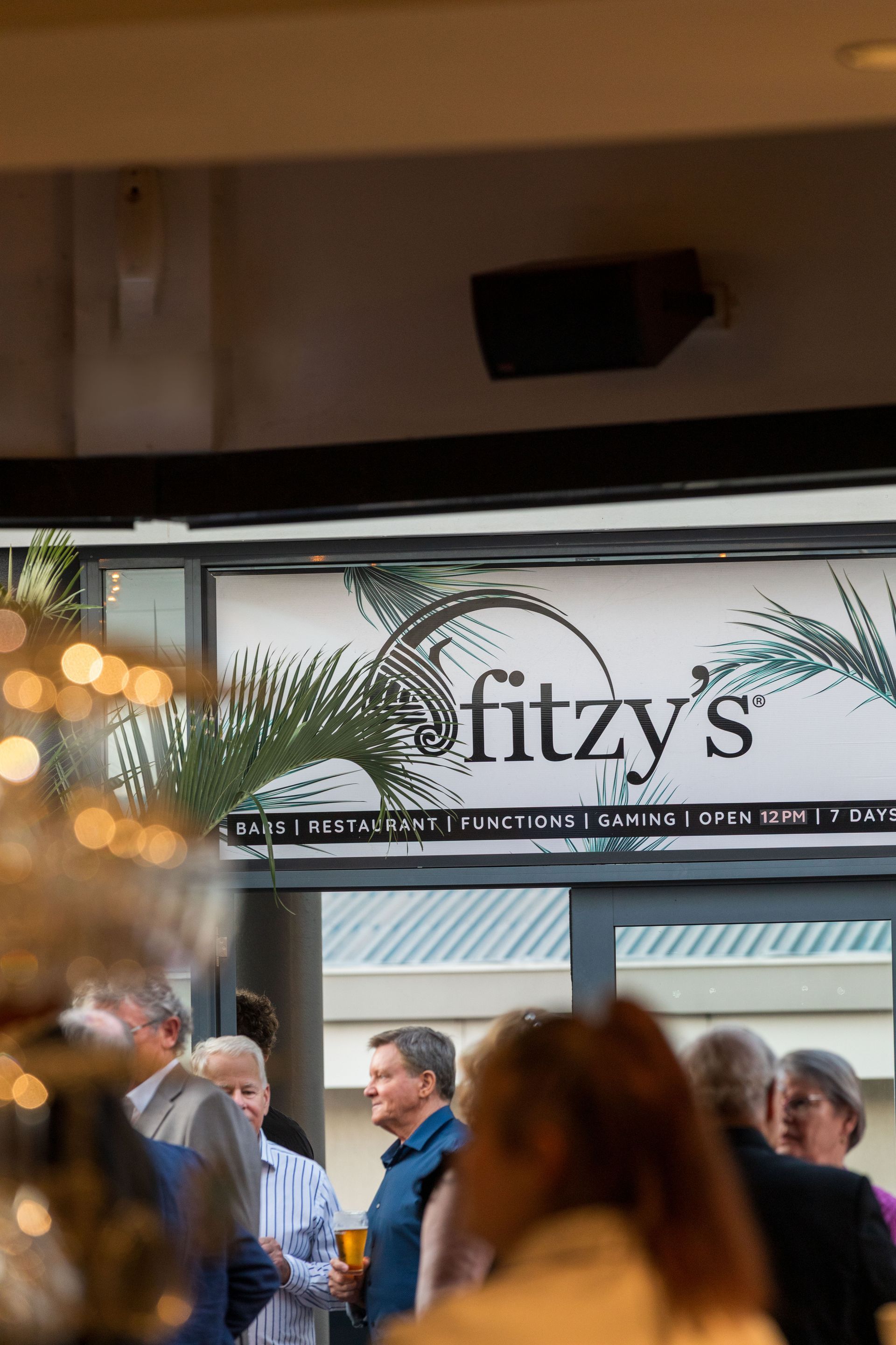 Crowded entrance beneath a “fitzys” sign, with people gathered outside the venue.