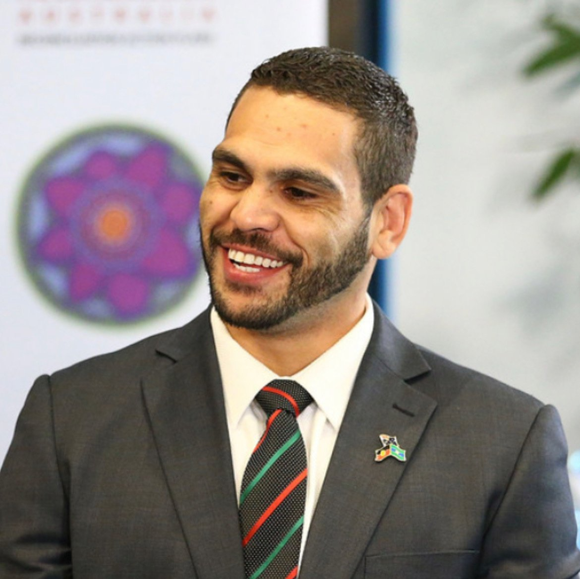 A man in a suit and tie is smiling