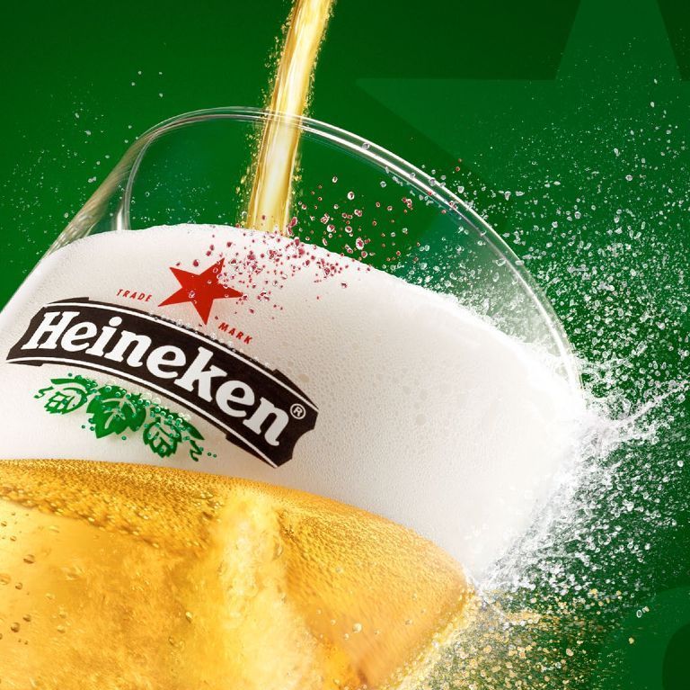 A glass of heineken beer is being poured into it