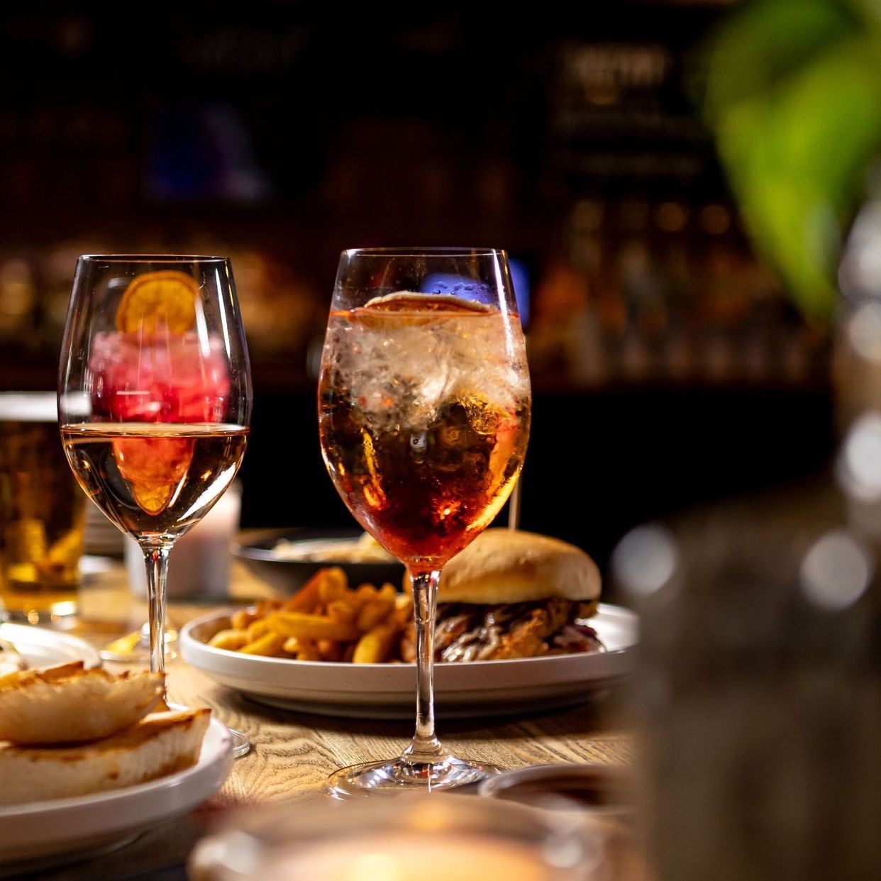 Four different types of drinks are sitting on a bar counter.