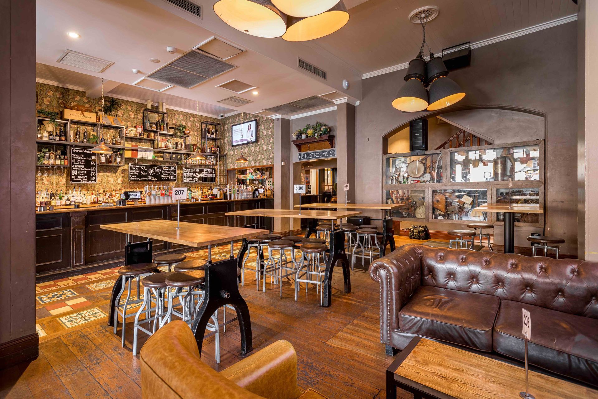 A restaurant with tables , chairs , a couch and a bar.