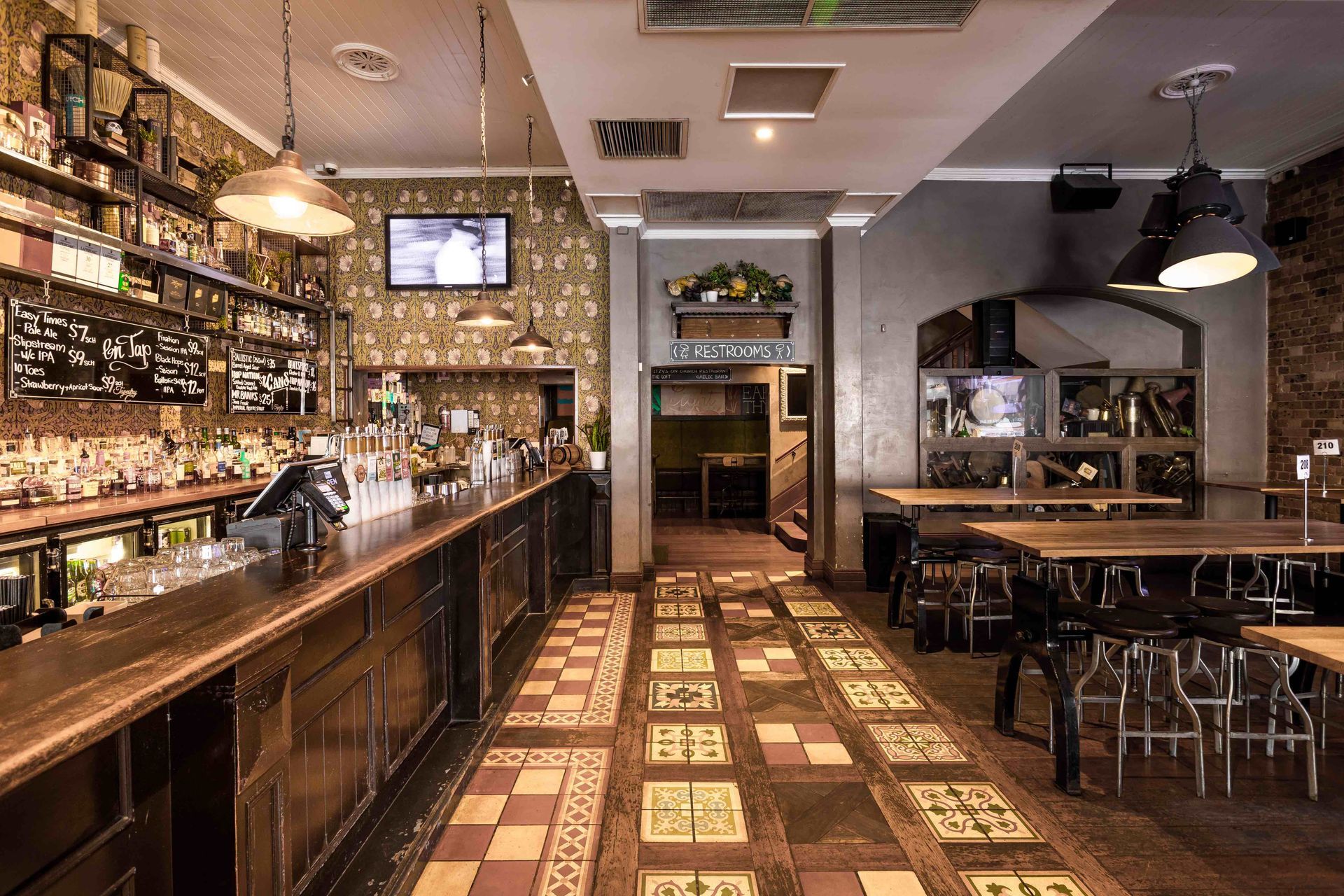 A large room with a long bar and tables in a restaurant.