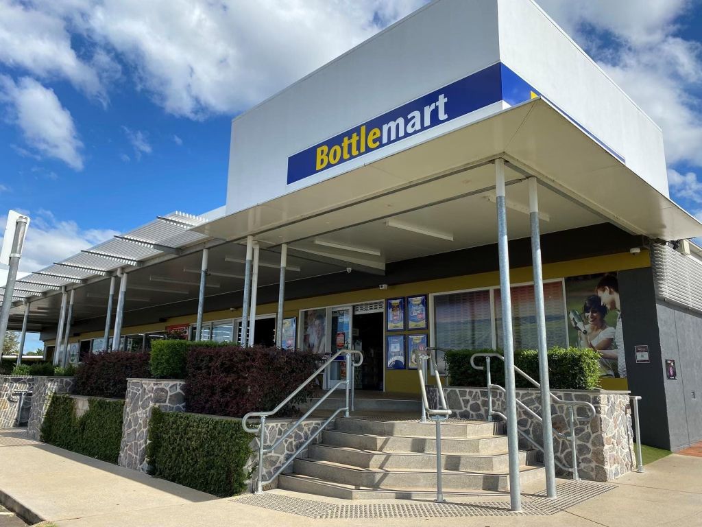 The front of a bottlemart store with stairs leading up to it.