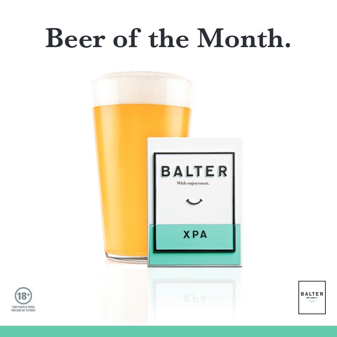 A glass of beer next to a box of balter xpa