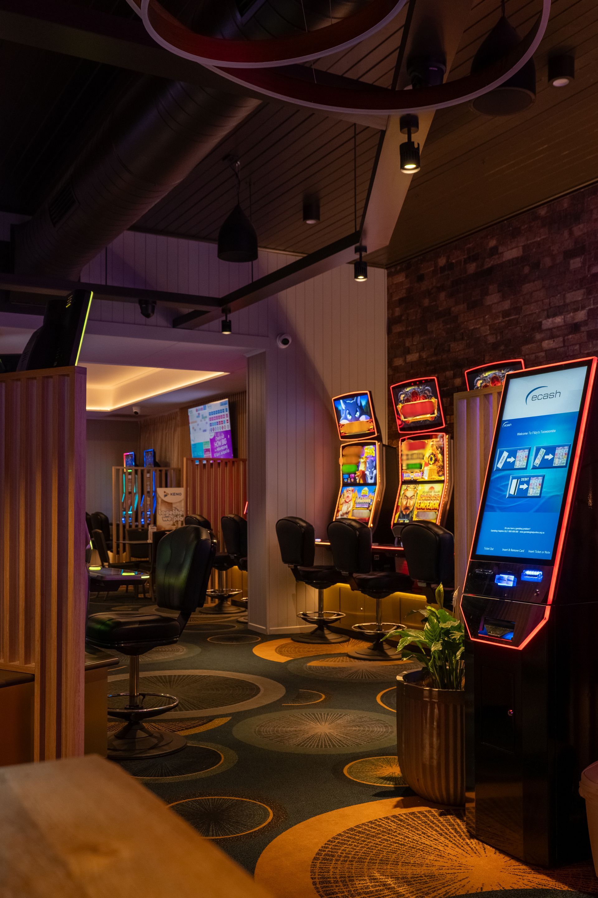 A casino with a lot of slot machines and chairs