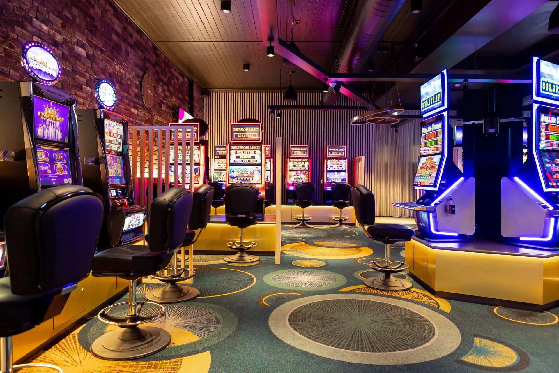 A casino with a lot of slot machines and chairs.