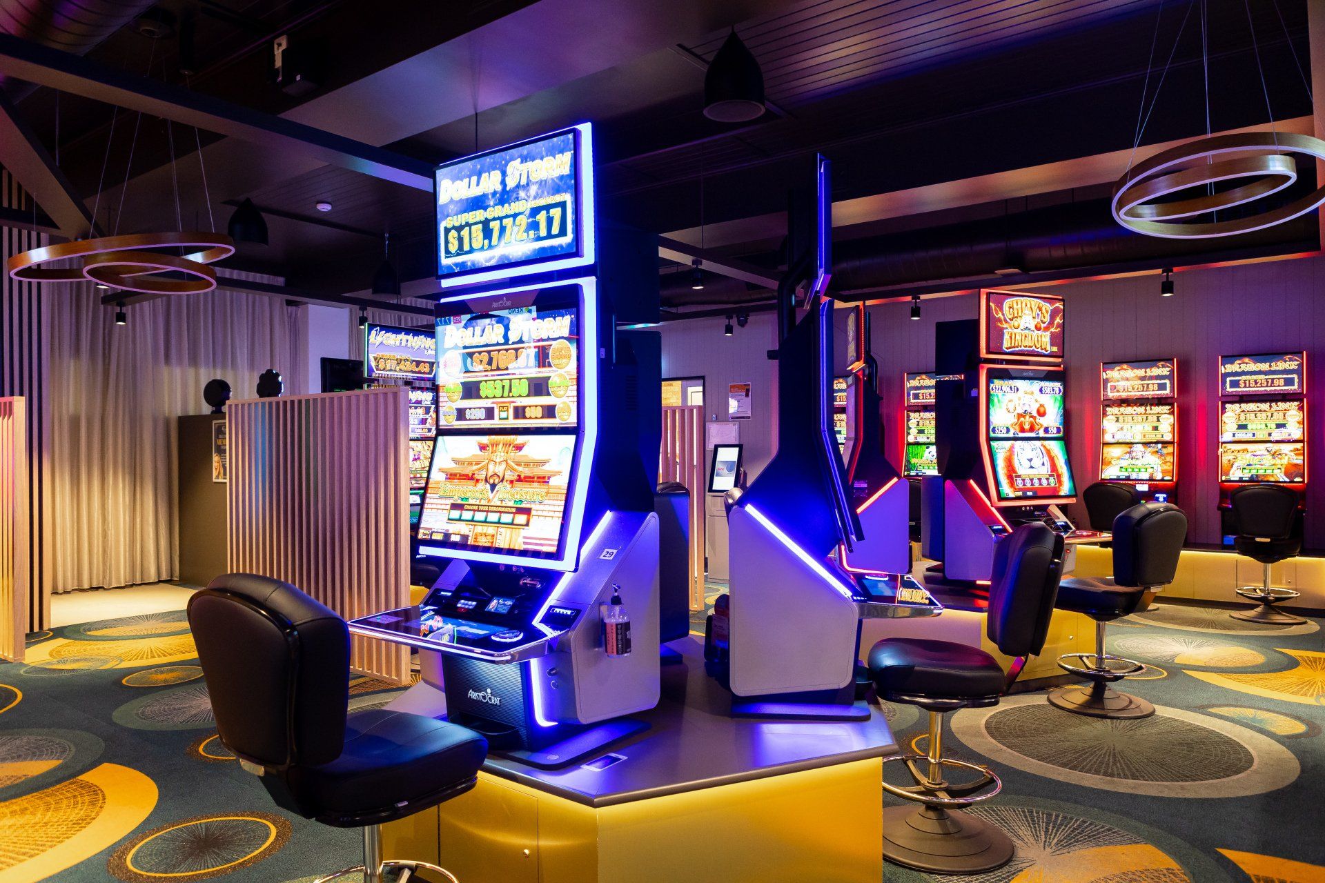 A casino with a lot of slot machines and chairs.