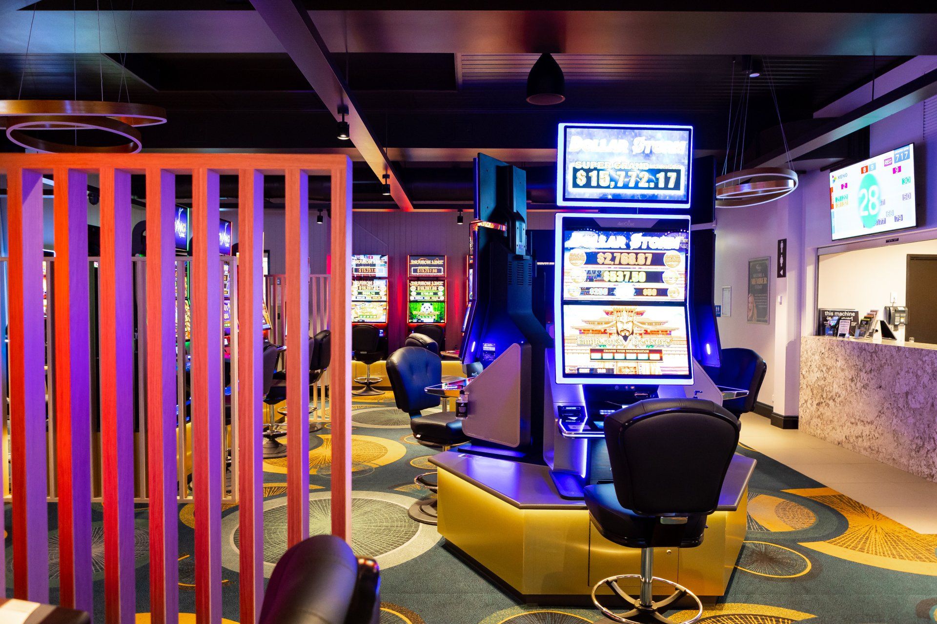 A large room with a lot of chairs and a slot machine.
