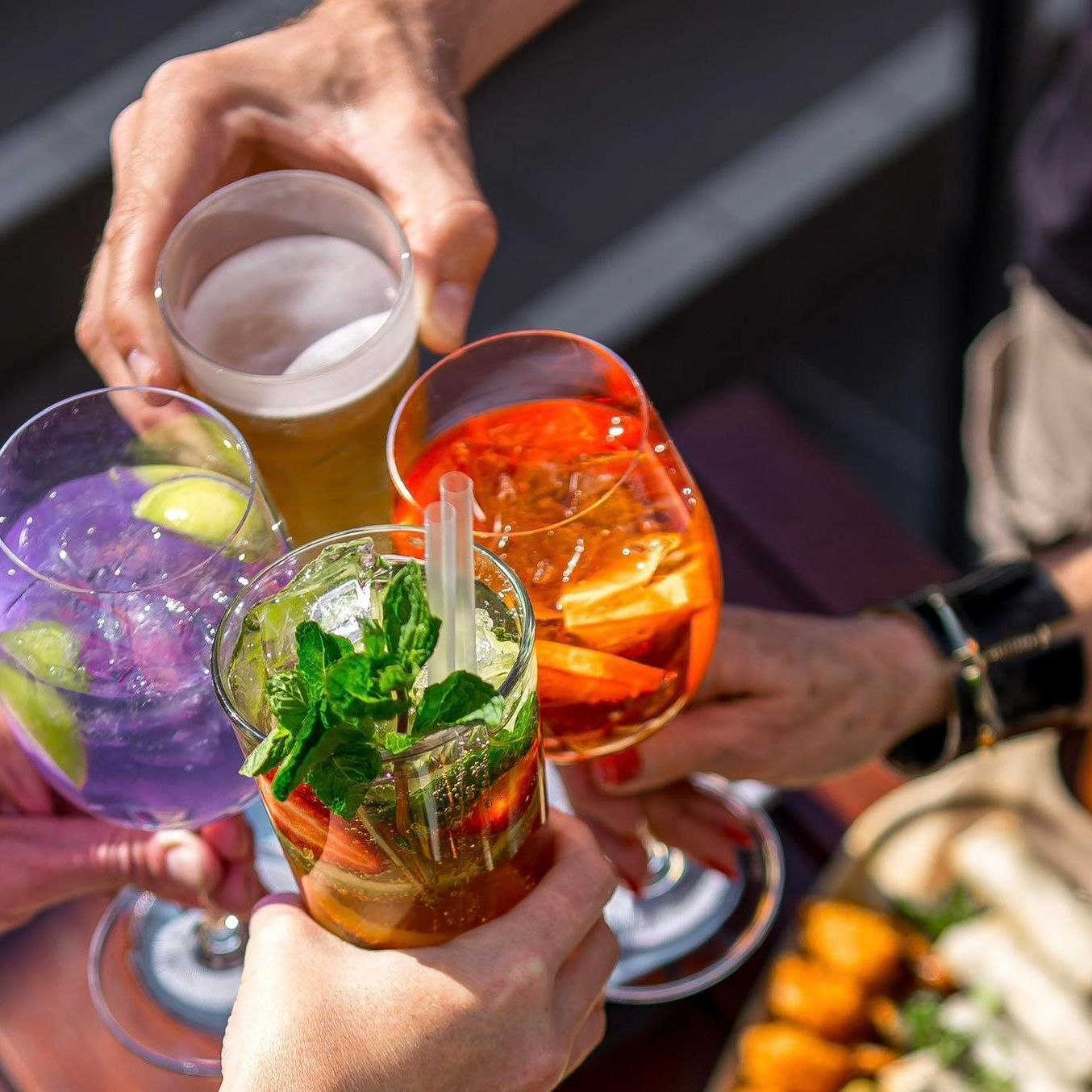 A group of people are toasting with their drinks