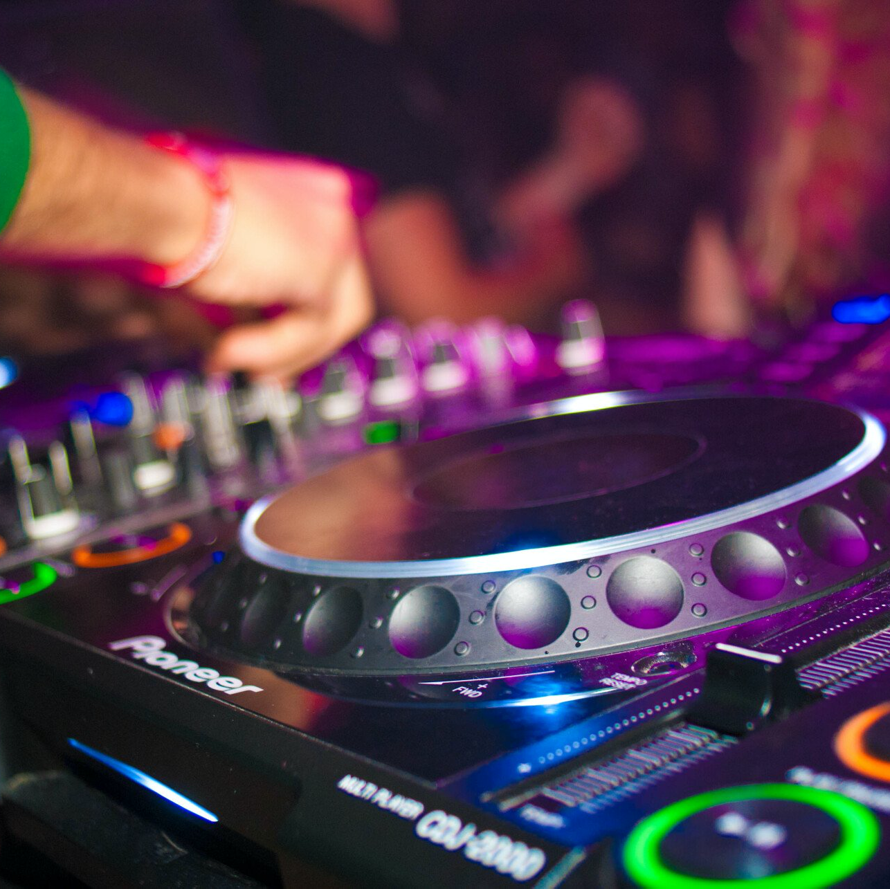 A dj is playing music on a pioneer mixer