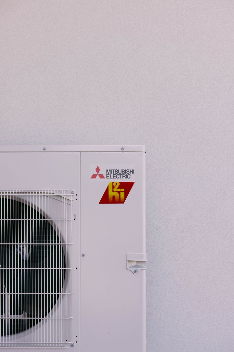 Air conditioning units with toolbox and gloves in backyard.