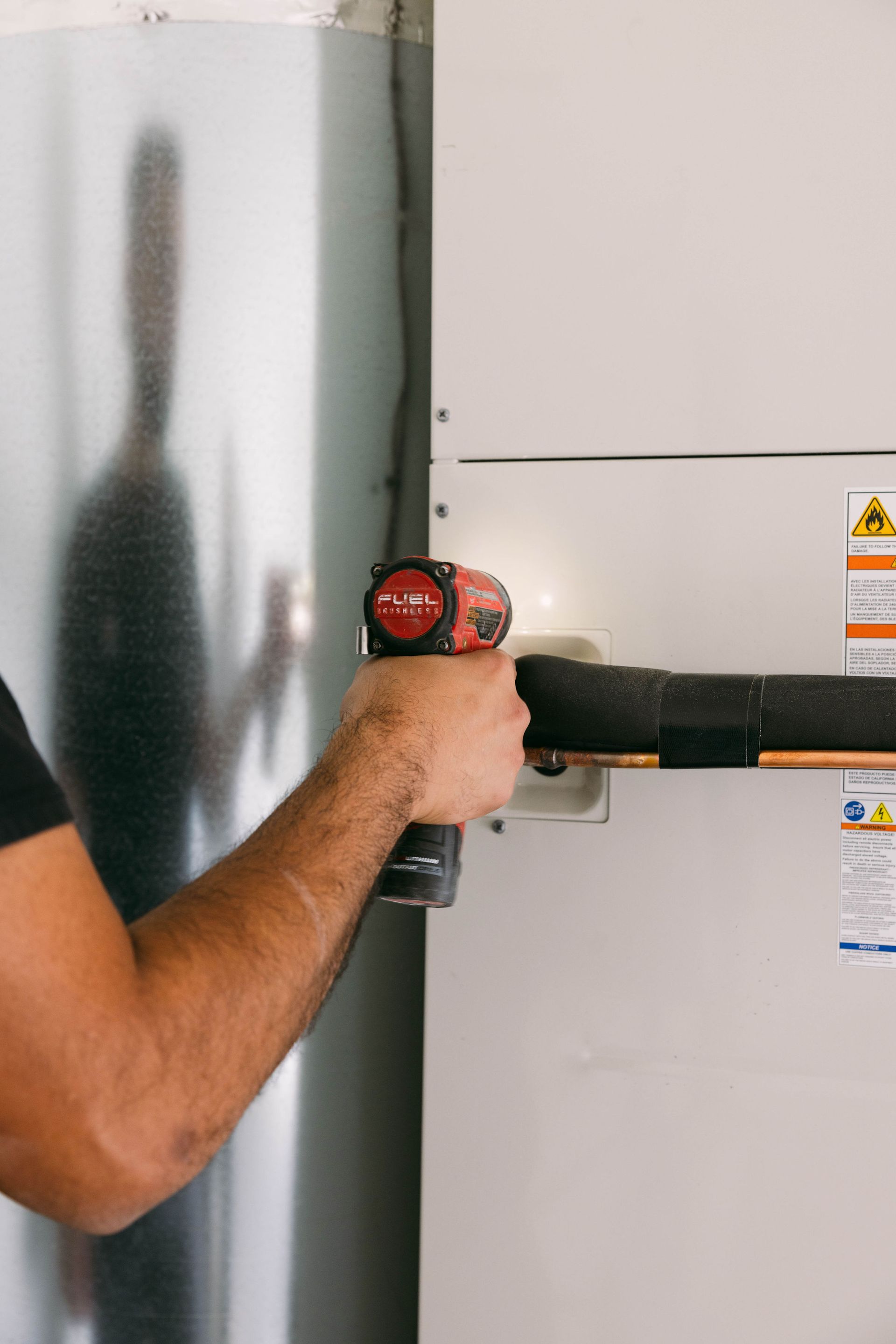Person using a laser level on a white wall indoors