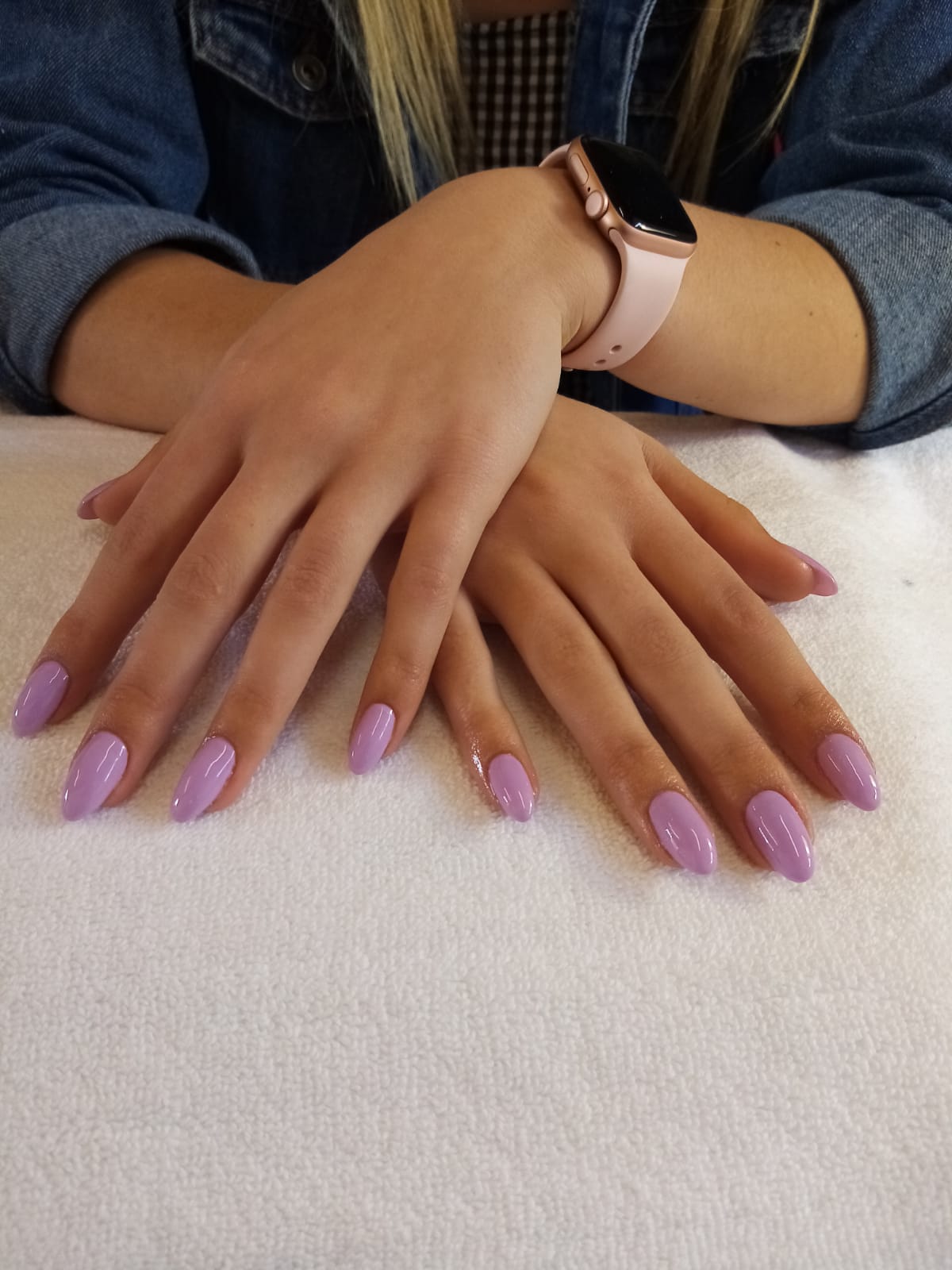 A woman 's hands with purple nails and a watch on her wrist