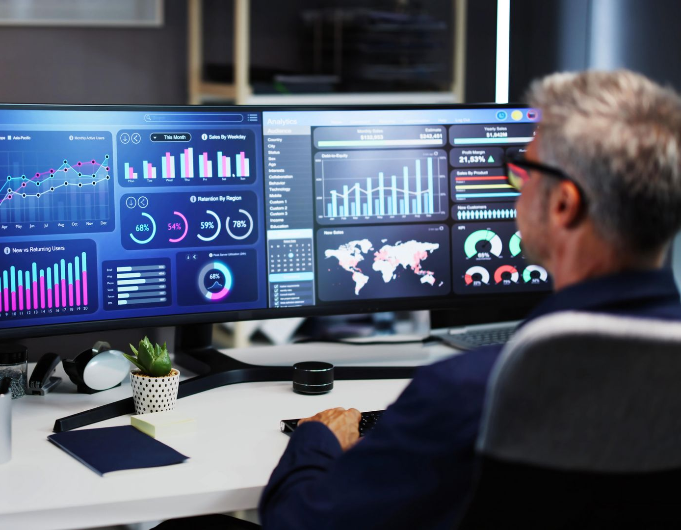 Person viewing multiple financial data dashboards on large monitors in a modern office