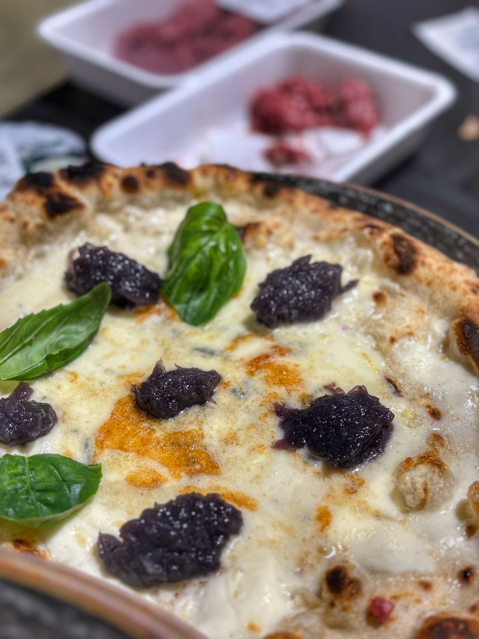 Una pizza è appoggiata su un bancone di marmo.