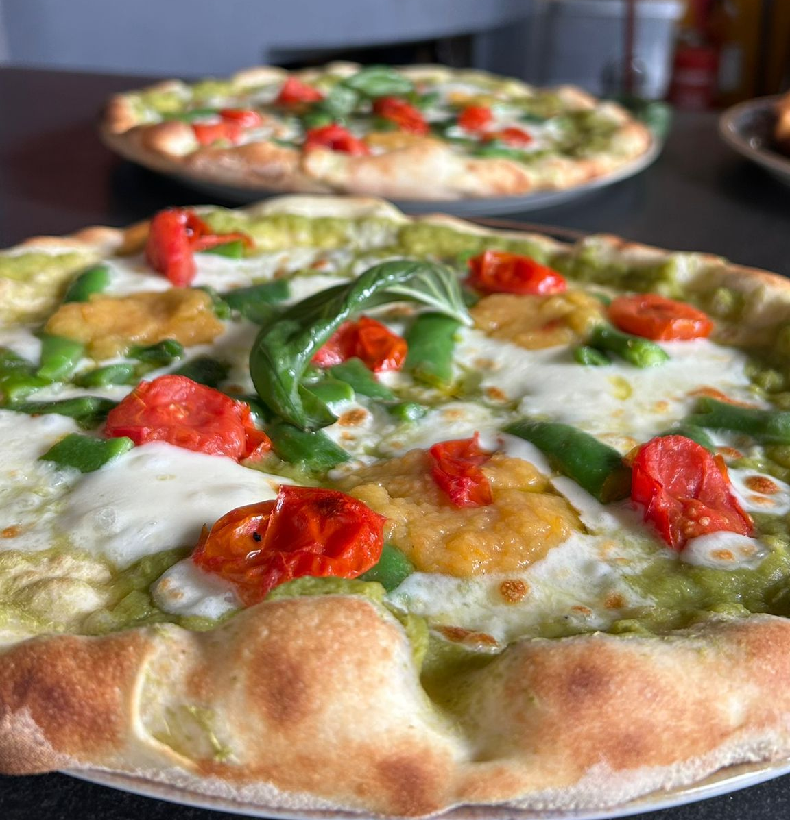 Una pizza è appoggiata su un bancone di marmo.