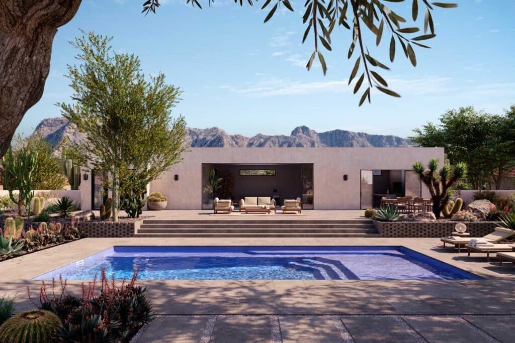 Desert home with a swimming pool, patio seating, and mountains in the background under a clear sky