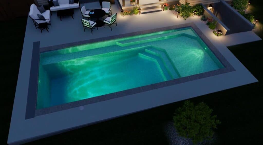 Modern backyard pool lit at night, with turquoise water, patio furniture, and surrounding landscaping.